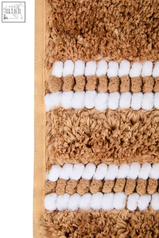 Soak large camel bath mat with tan and white stripes and plush textured surface for cozy bathroom use