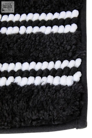 Large charcoal grey bath mat with plush textured surface and black and white stripes for bathroom use