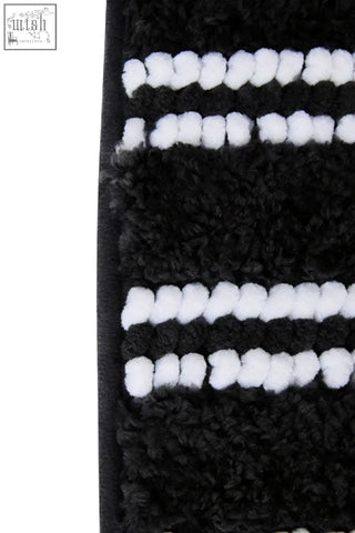 Large charcoal grey bath mat with plush textured surface and bold black and white stripes for cozy bathroom use