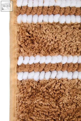 Tan and white striped plush small camel bath mat with a textured surface perfect for bathroom use
