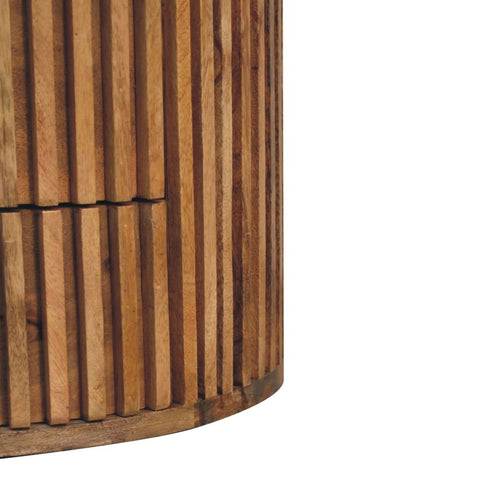 Cylindrical bedside table with vertical slats made of solid mango wood in light brown natural oak finish