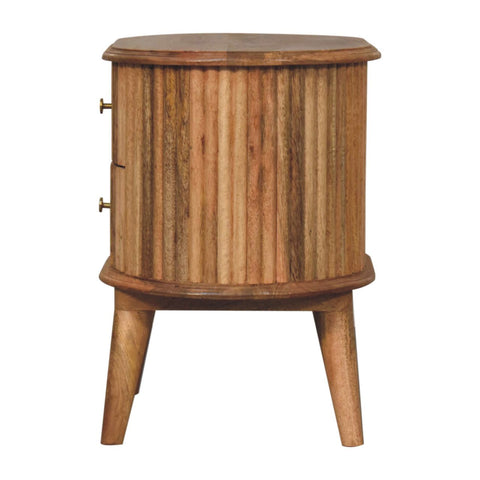 Rustic oak mango wood bedside table with vertical fluted panels, brass handles, and tapered legs in nordic style