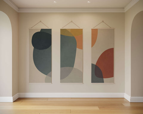 Three vertical abstract shapes tapestry panels with soft abstract shapes in muted gray teal ochre and terracotta tones on beige