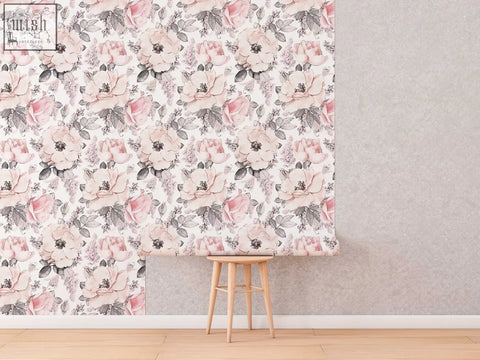 Soft pink abstract roses peel and stick floral wallpaper with muted gray leaves on wall by wooden stool for living space