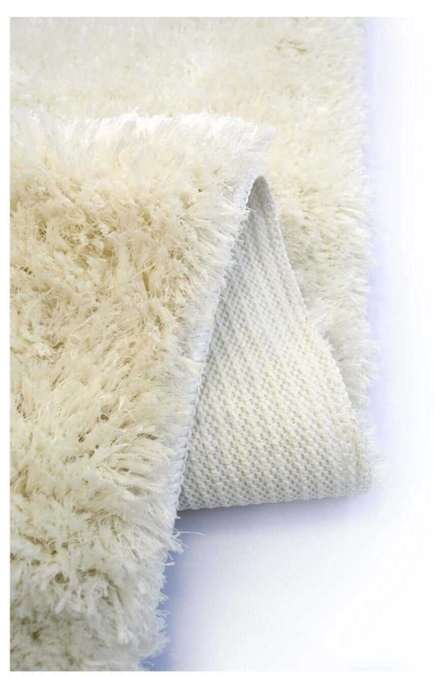Cream-colored soft washable ivory shaggy rug with plush high-pile texture and visible woven backing backside view