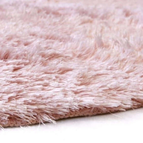 Soft washable pink shaggy rug with plush fluffy texture and slightly frayed edges perfect for cozy spaces