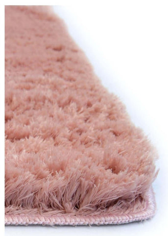 A soft washable pink shaggy rug with fluffy texture and neatly stitched edges perfect for cozy spaces