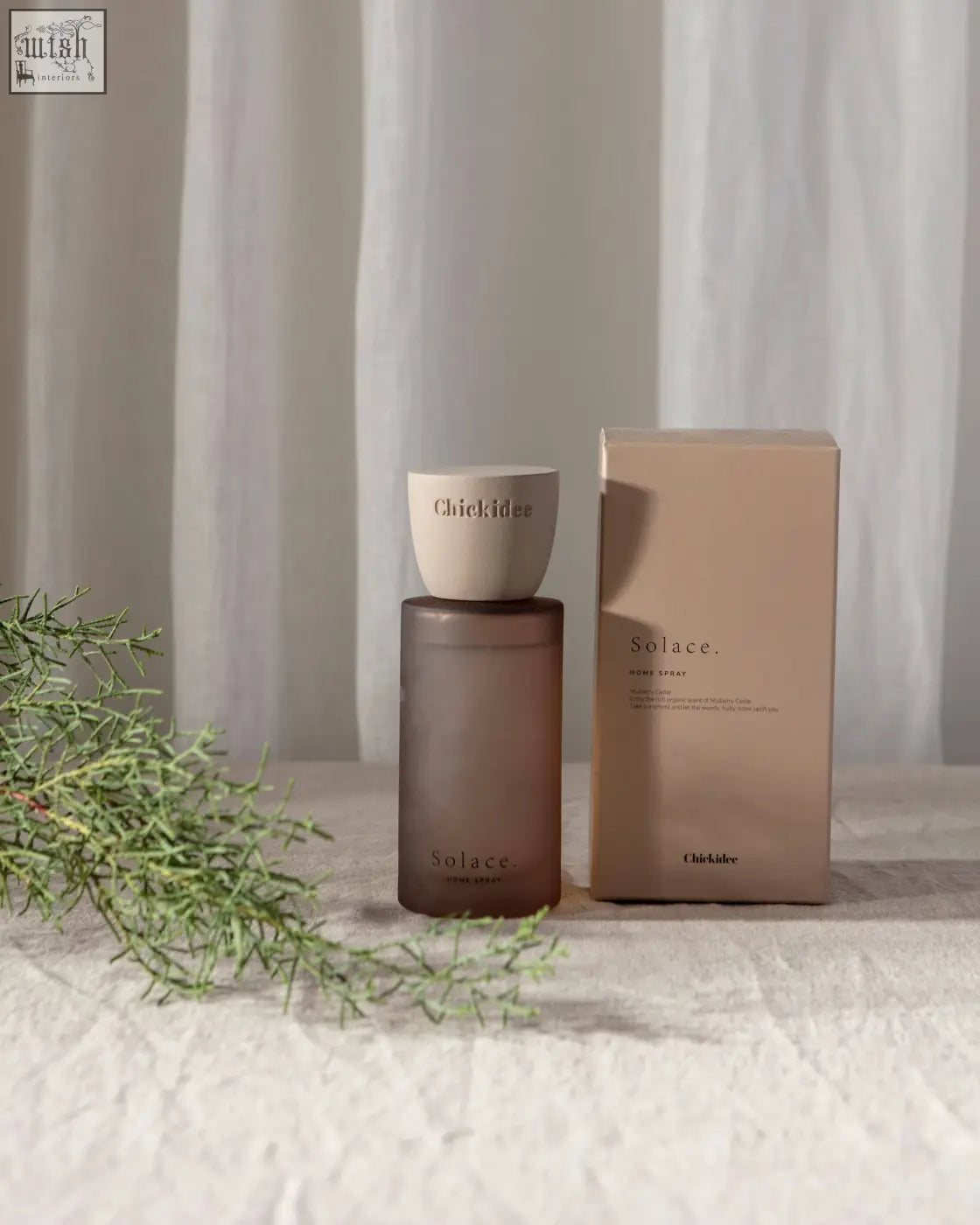 A sleek matte brown glass bottle with a white ceramic cap for solace clay home spray by chikides
