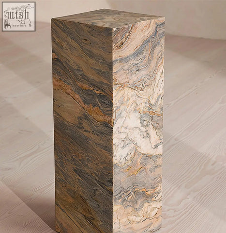 A solara plinth side table made of brazilian quartzite stone with beige brown and gray swirling marble patterns