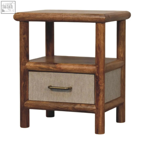 Rustic solara rattan bedside table with a single drawer featuring beige fabric paneling and brass handle