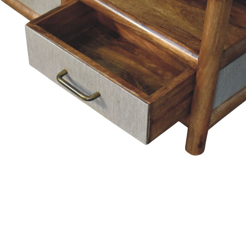 A rustic solara rattan coffee table drawer with textured gray fabric front and brass handle in matching wood frame