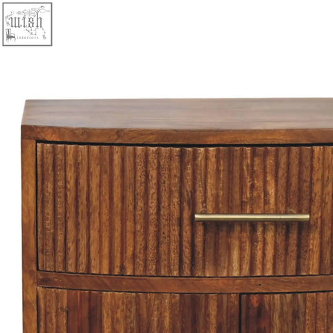 Solid wood curved bedside drawer in oak mango wood with vertical ribbed detailing and brass handle