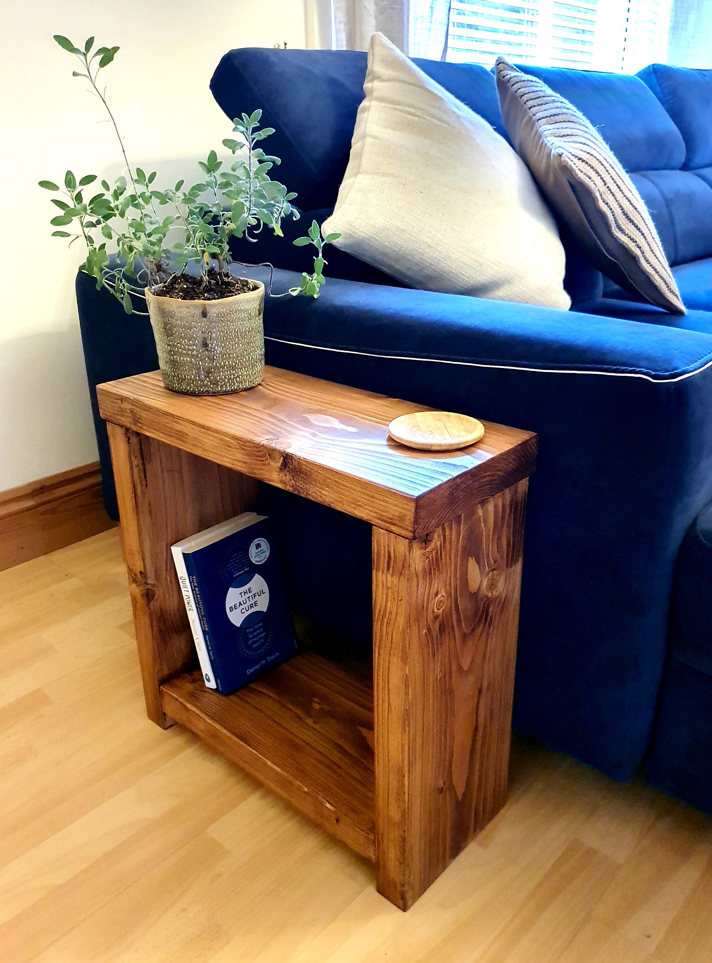 Solid wood rustic coffee table with natural finish and visible grain featuring a lower shelf holding a book