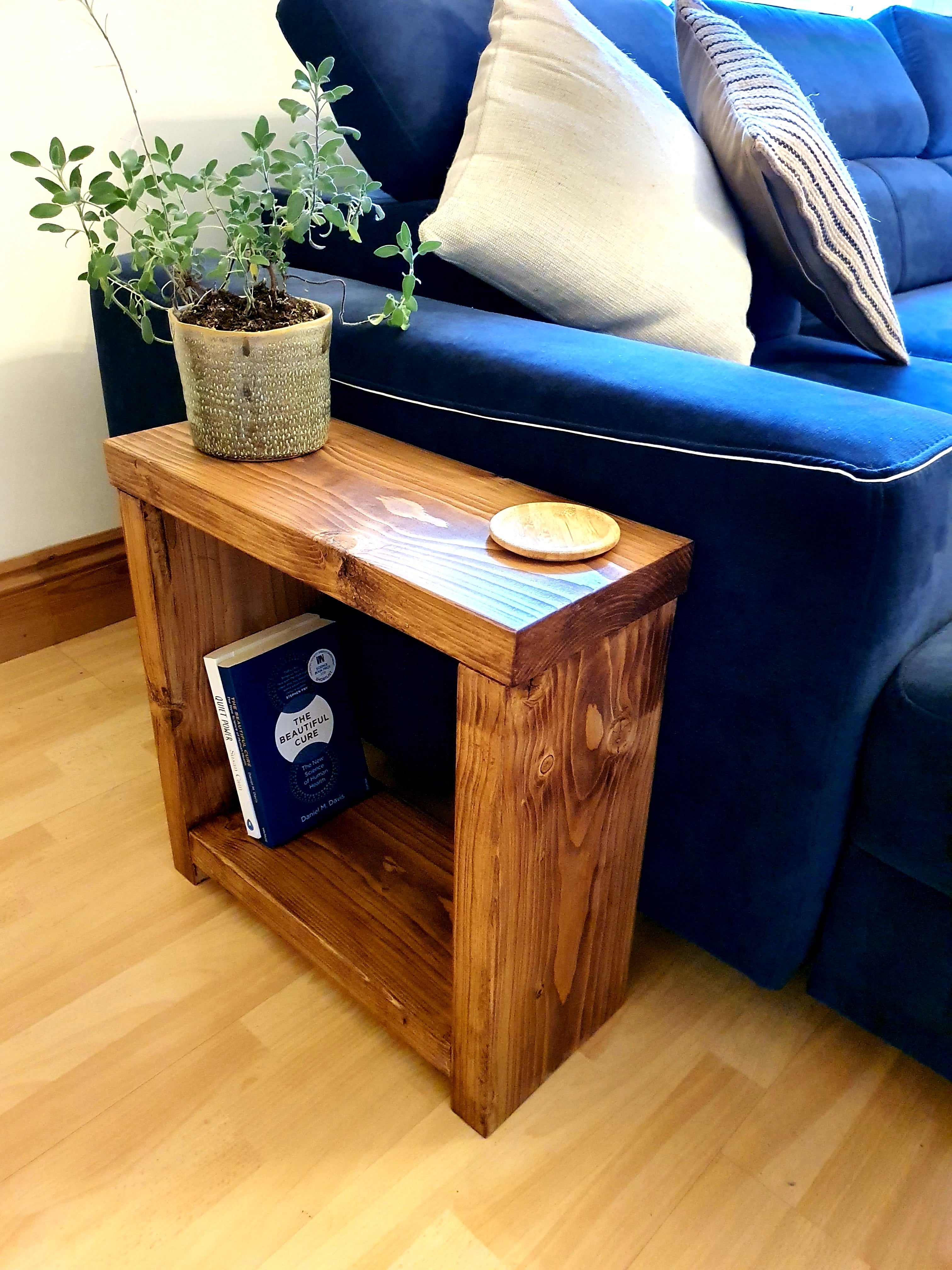 Solid wood rustic coffee table with a natural finish, timber legs, and an open shelf holding a book underneath