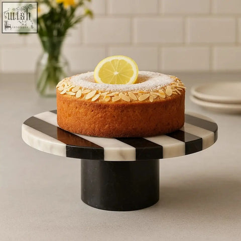 A round lemon cake with almonds on a white marble round cake stand perfect for serving treats