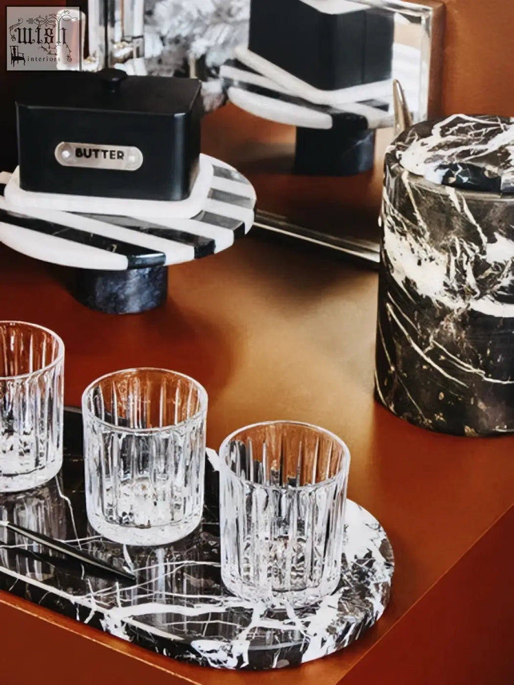 Three clear ribbed glass tumblers on soma small black and white marble round cake stand with white marble round tray