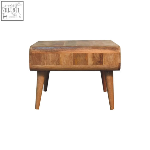 A rustic sonata oak-ish coffee table with a patchwork top oak-like finish and rounded edges on tapered legs