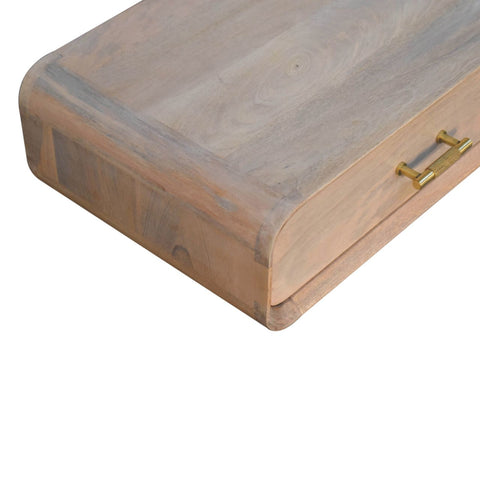 A light-colored rustic wooden wall mounted bedside table with smooth finish and gold-toned metal handle