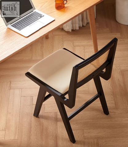 Black-framed sophia rattan dining chair with beige cushion and woven cane backrest perfect for dining room