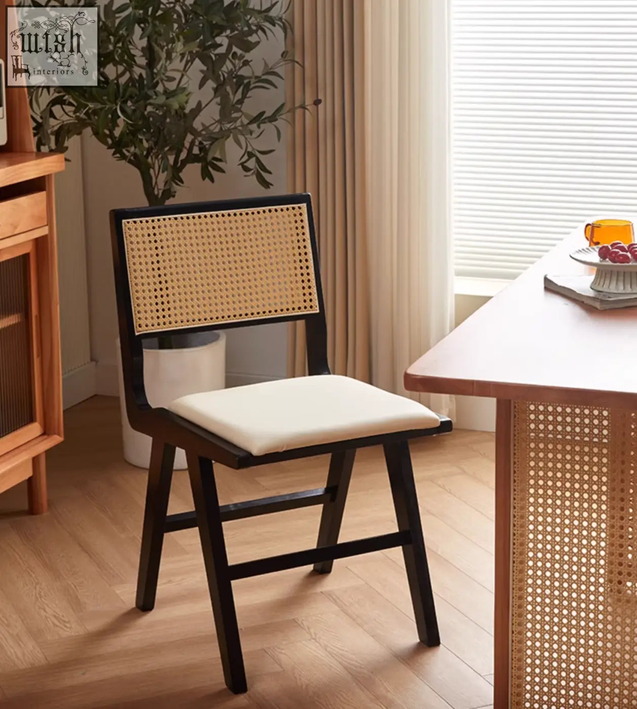 Black-framed sophia rattan dining chair with woven cane back and cream upholstered seat perfect as rattan dining chair