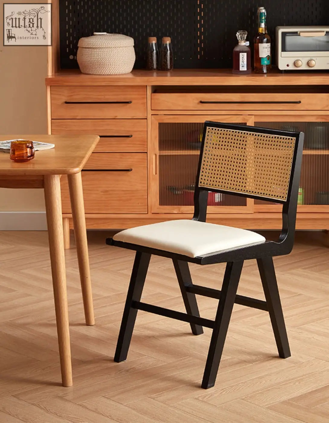 Black-framed sophia rattan dining chair with woven cane back and white upholstered seat perfect for dining room