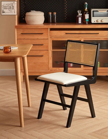 Black-framed sophia rattan dining chair with woven cane back and white upholstered seat perfect for dining room