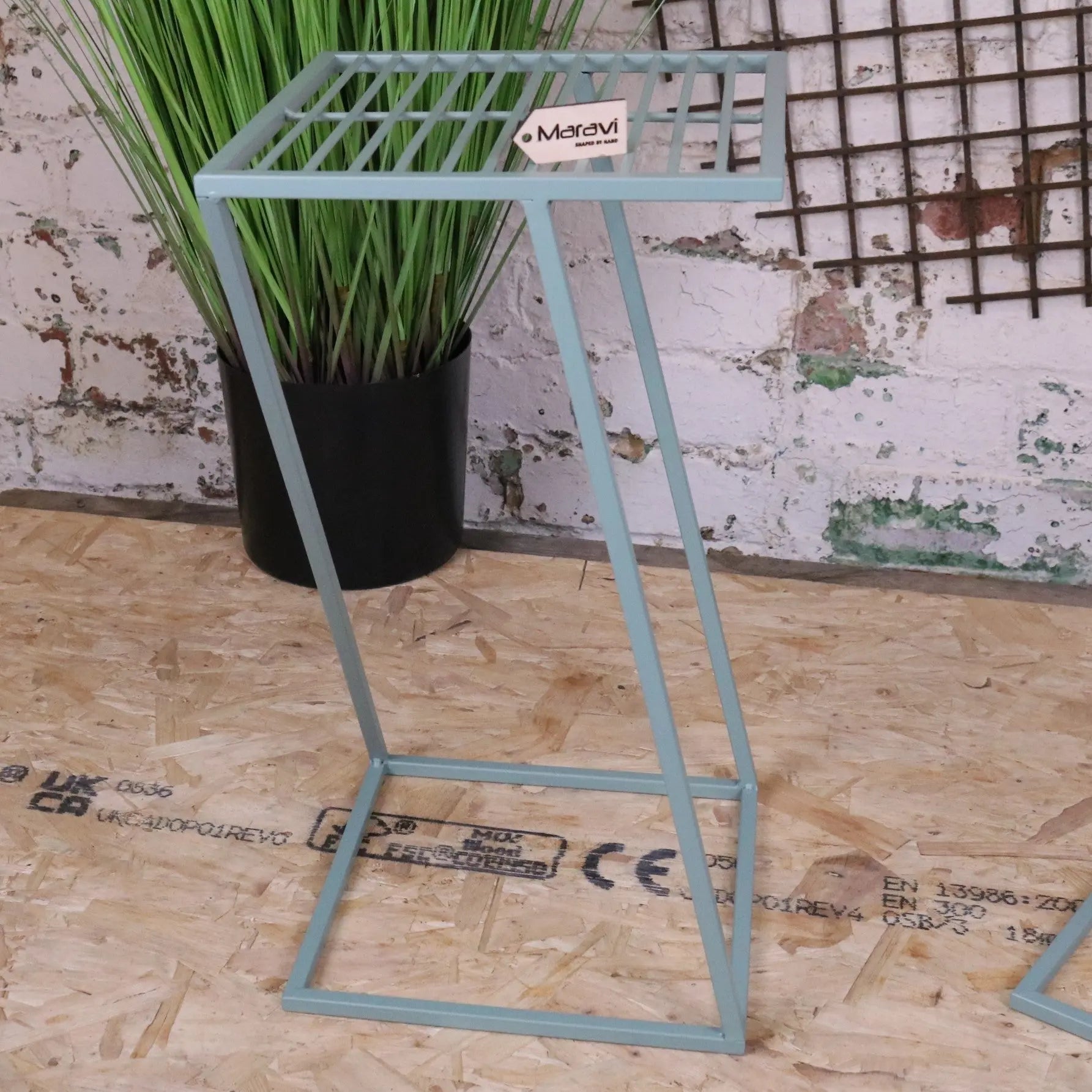 Light blue metal plant stand with grid top and angled legs from soraya green garden table set for outdoor use