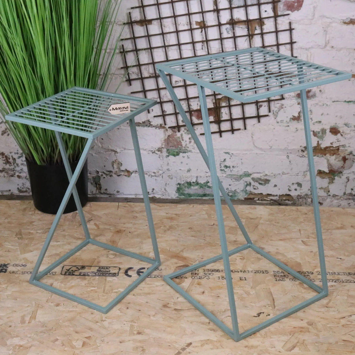 Two light blue metal wire plant stands with geometric design part of soraya green garden table set