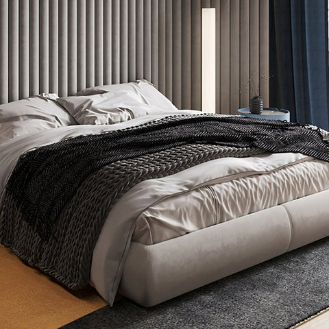 Modern soren king size bed in grey with tufted upholstered headboard dressed in white linens and black knit throw