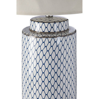 A tall sorino ceramic table lamp with a white and blue geometric pattern and a cream shade on a silver base