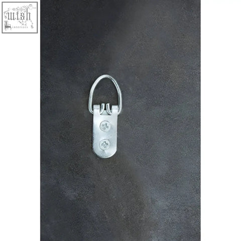 Back side of sorrel wall mirror showing silver metal picture hanging hook with d-shaped loop and two screw holes for hanging