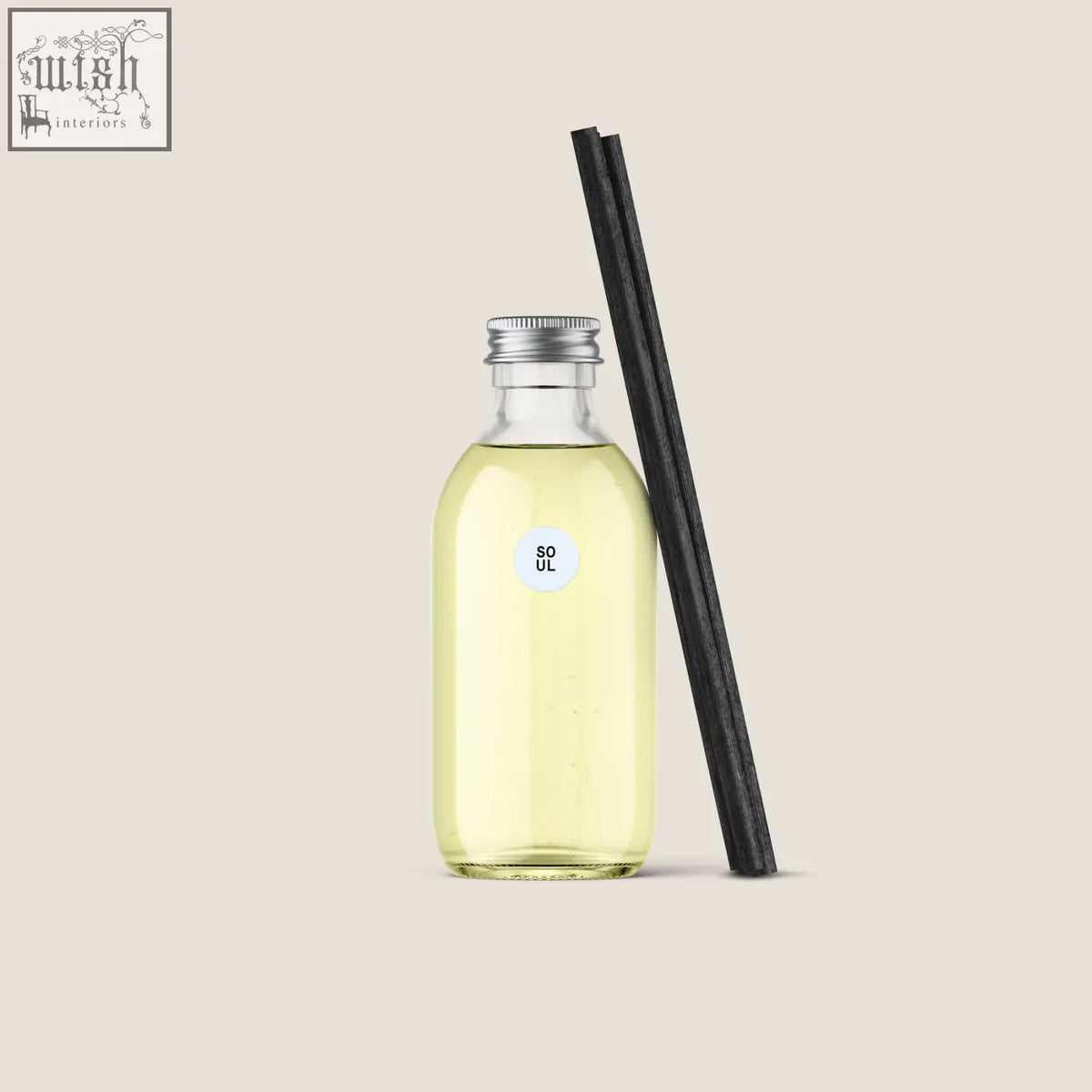 A clear glass bottle of pale yellow soul diffuser refill with a silver cap and two black reed diffuser sticks