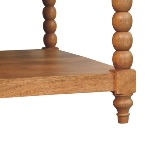 Light brown golden teak coffee table with turned bead legs and smooth natural wood grain finish for living room