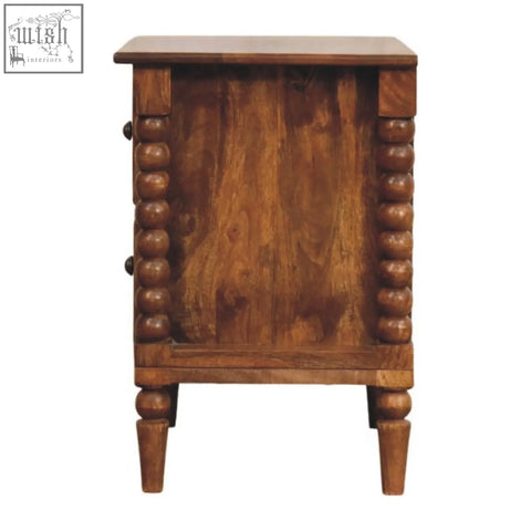Rustic amber oak bedside table with turned spindle legs and decorative bead detailing on its sides and legs