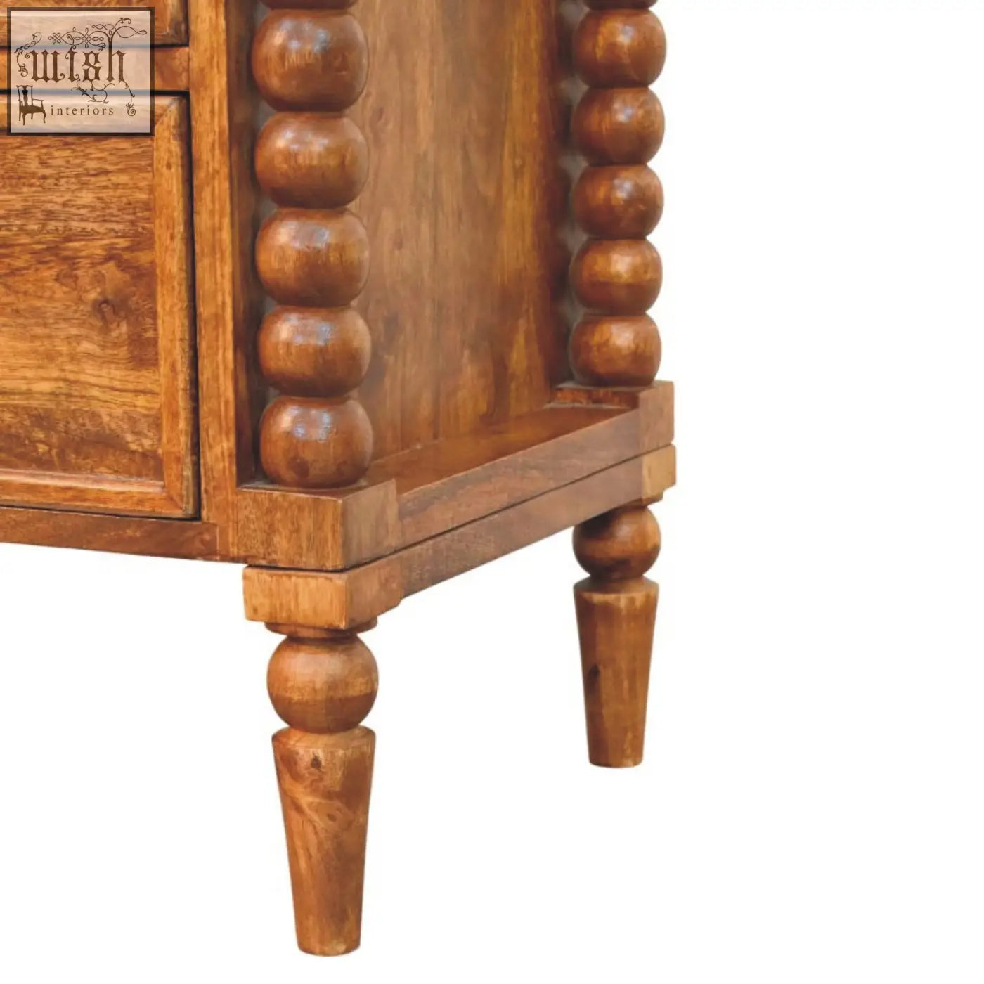 Warm-toned amber oak bedside table with turned spindle legs and bead detailing on frame and legs