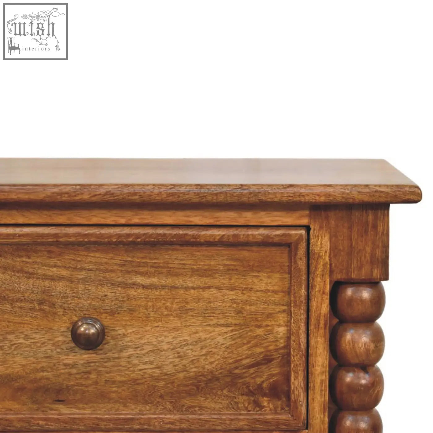 Warm-toned amber oak bedside table with turned spindle legs and polished wooden finish with decorative beads
