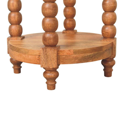 Spindle round side table with turned spindles lower shelf in warm golden teak finish natural wood design