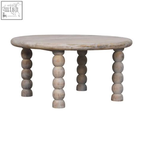A round light-washed spindle salted oak coffee table with turned bead legs made from oak-ish solid mango wood