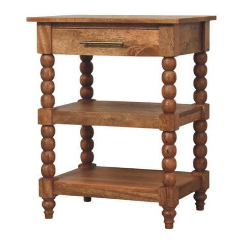 Rustic spindle side table with golden teak finish, turned bead legs, single drawer with brass handle, and two open shelves