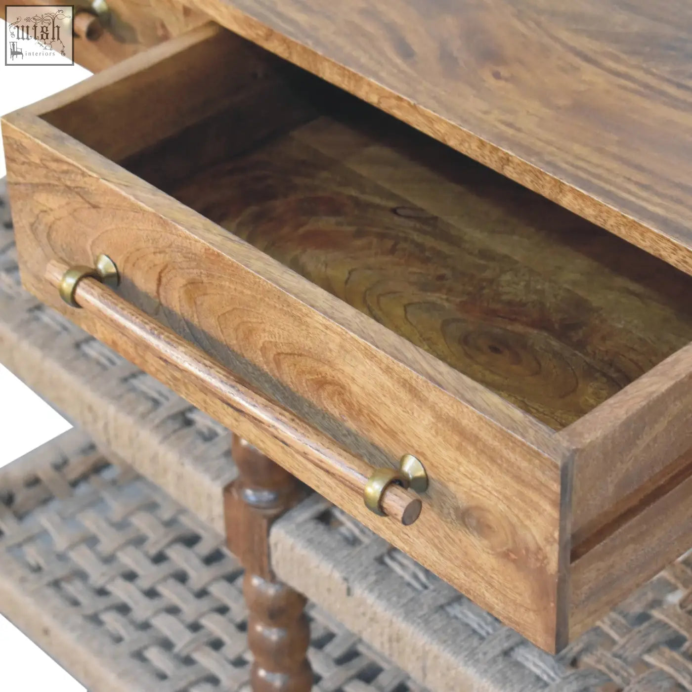 Rustic spindle woven console with a warm natural wood finish and brass handles on the front drawer