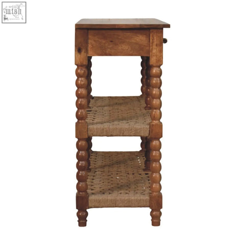 A rustic wooden spindle woven console with turned bead legs, woven wicker shelves, and a single drawer