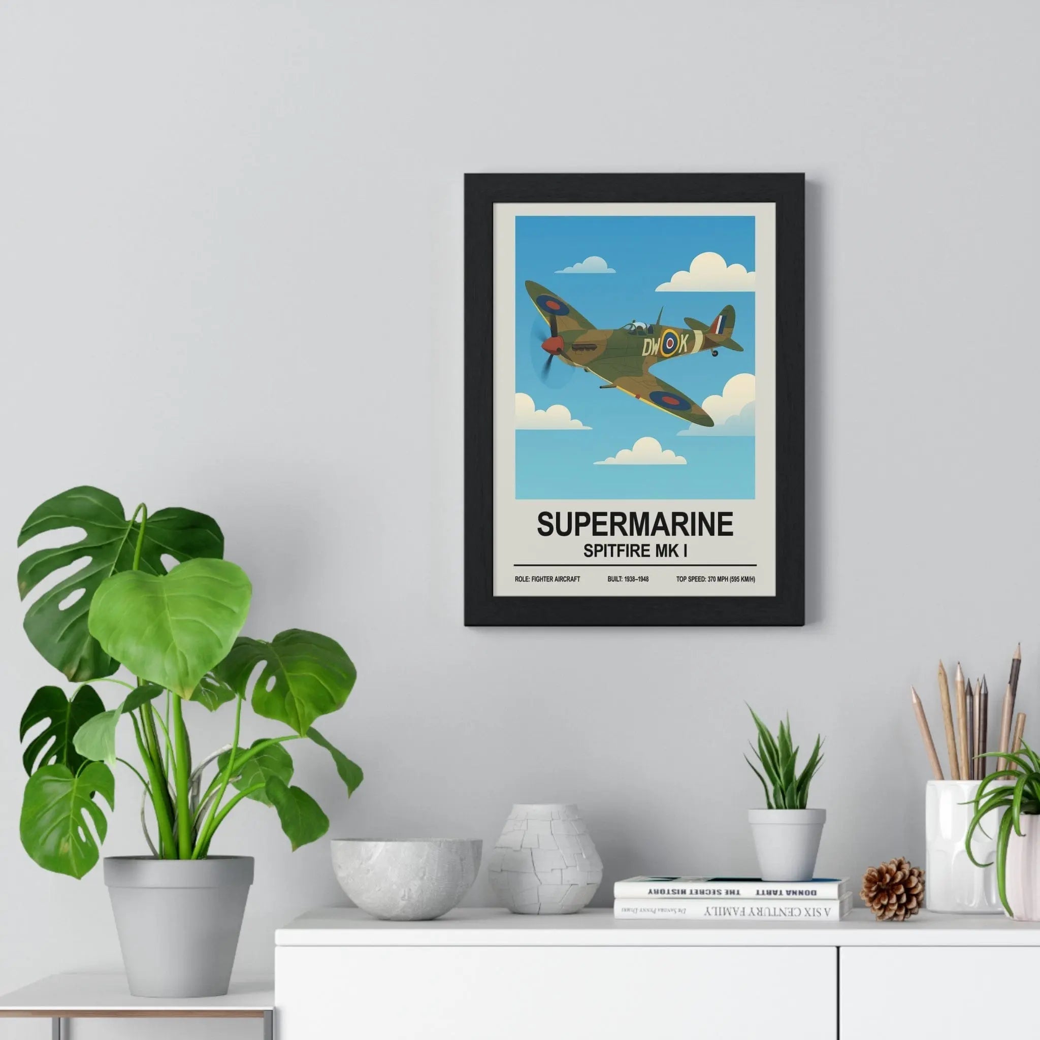 Black-framed spitfire poster featuring a vintage olive green supermarine spitfire mk i against a blue sky highlighting historical significance