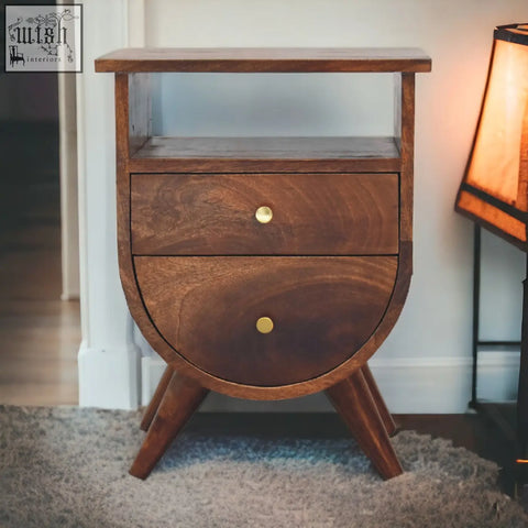A split chestnut bedside table with two curved drawers, brass knobs, tapered legs, and solid mango wood finish for storage