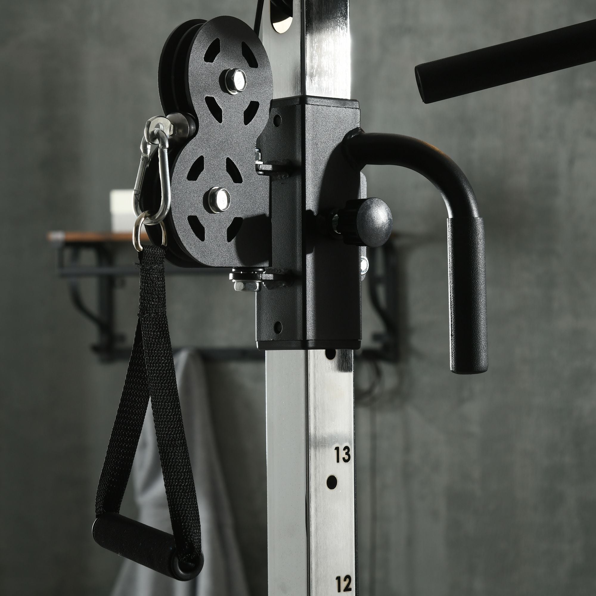 Black pulley system with textured grip handle and adjustable weight on a silver frame for sportnow home gym strength training