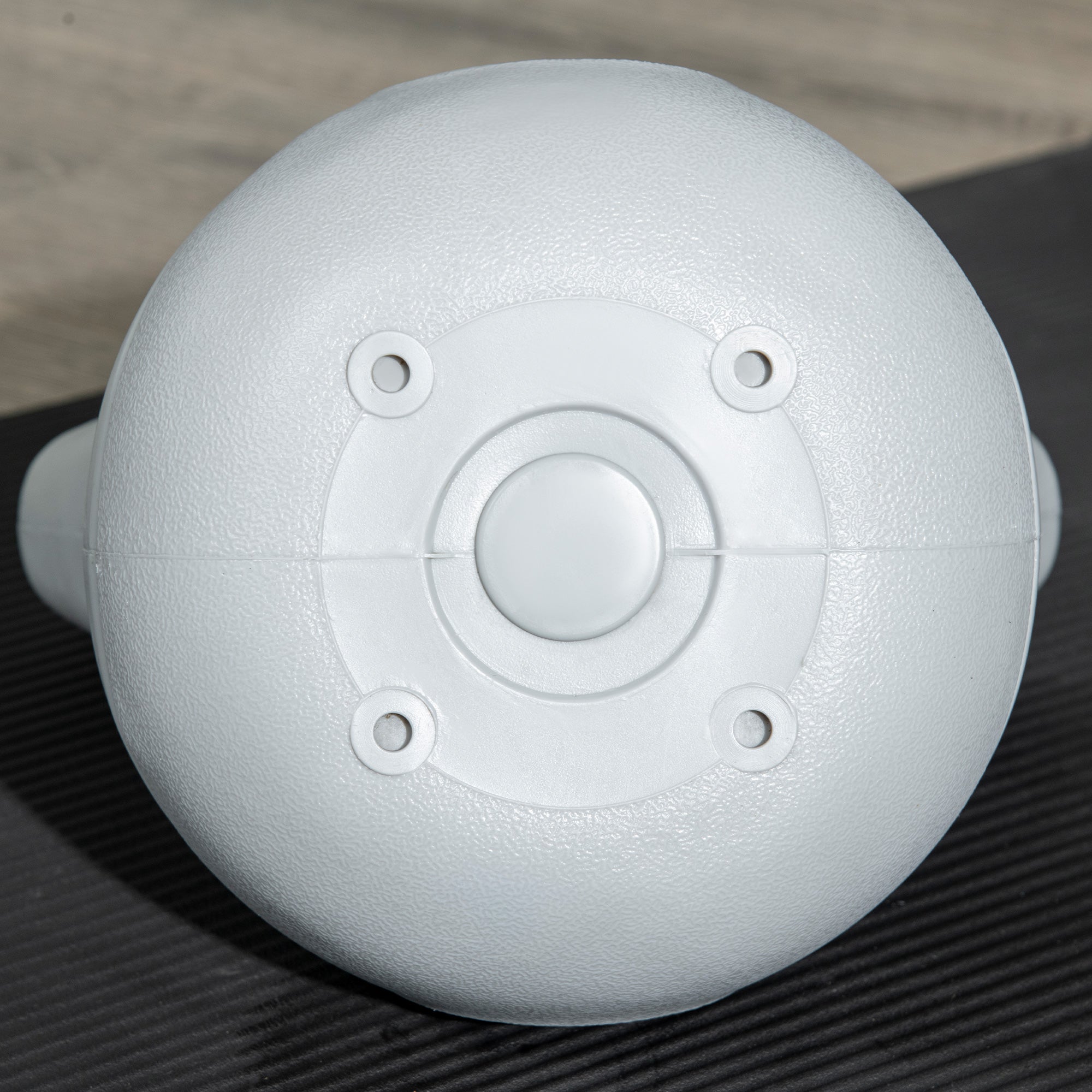 White matte plastic dome with four mounting holes and button on the back of a sportnow kettlebell for strength training