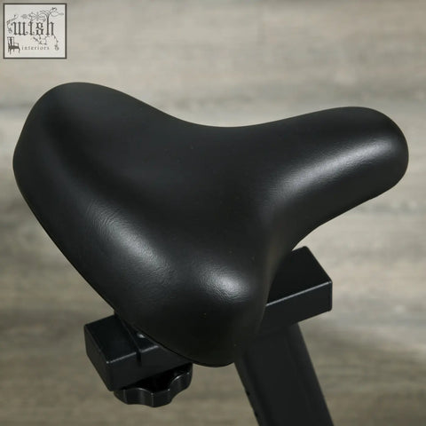 Black leather-like saddle on sportnow exercise bike with adjustable resistance and tablet holder for indoor cycling