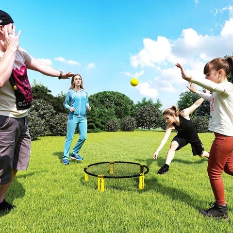Yellow ball bouncing off the black net with yellow foldable legs in the sportnow spike ball set for outdoor fun