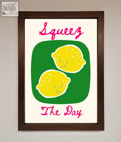 A day framed poster with two yellow lemons on green and pink script text squeeze the day in a stylish design