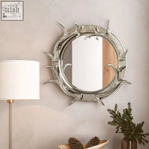 Silver stag antler steel wall mirror with a round nickel finish frame and polished metallic look