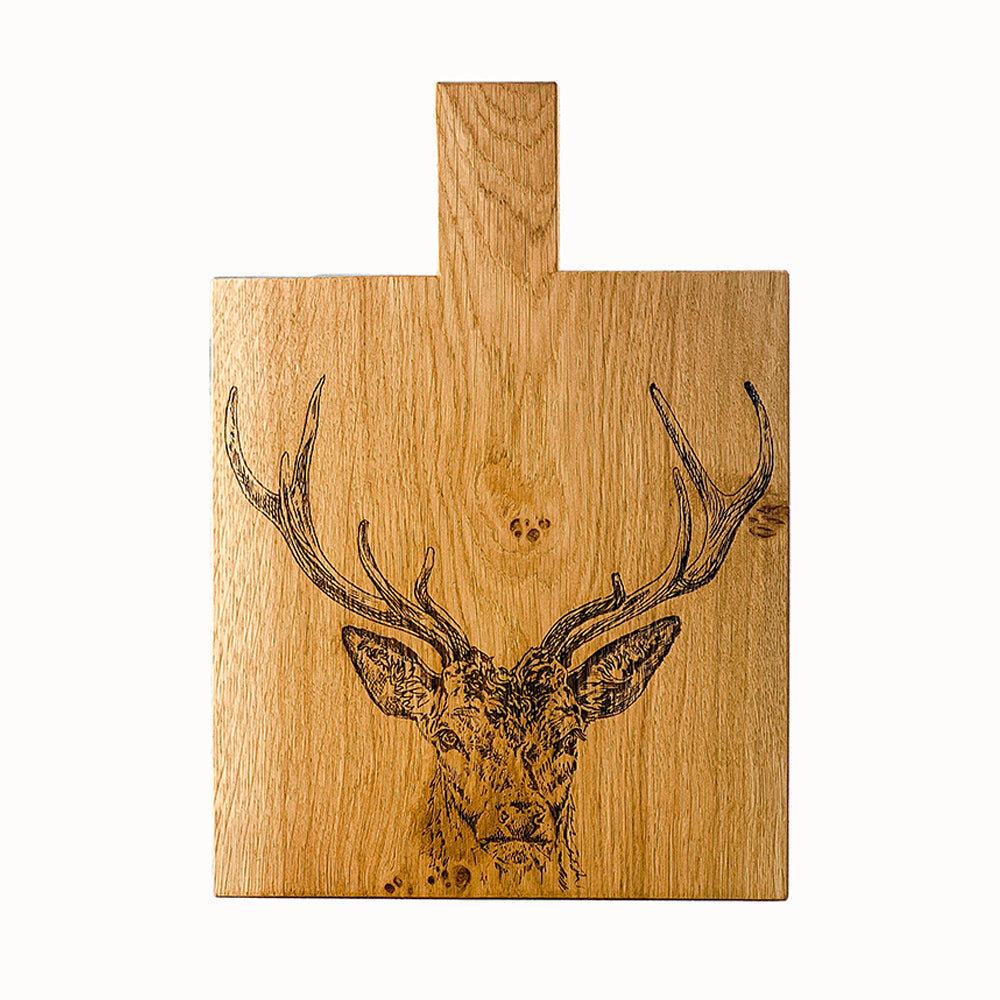 Light brown wooden stag prince oak paddle cutting board with laser engraved deer head and top handle medium size